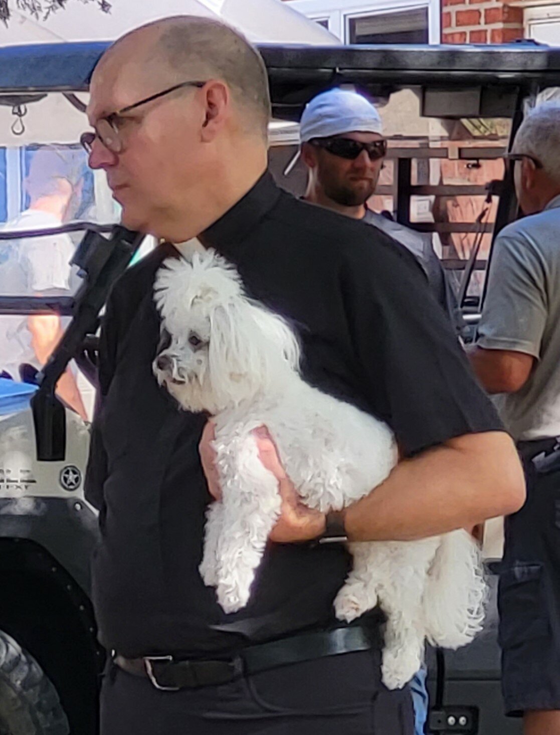 Father William Debo, pastor of pastor of Holy Family Parish in Freeburg and Sacred Heart Parish in Rich Fountain, and his Maltese dog, J.P., visit with parishioners at the Holy Family Parish Picnic Sept. 3.